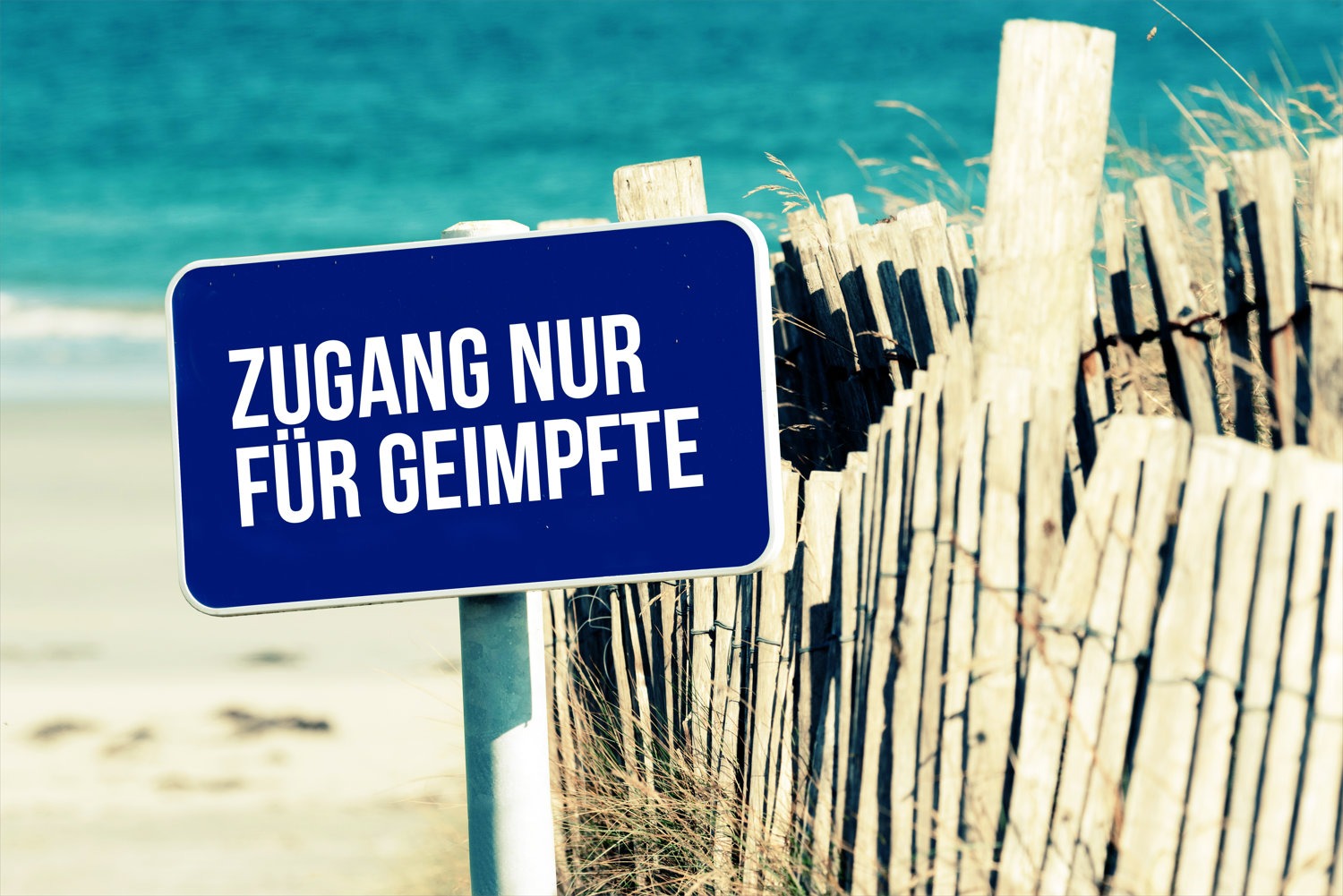 Foto: Schild „Zugang nur für Geimpfte“ an einem Strandzaun