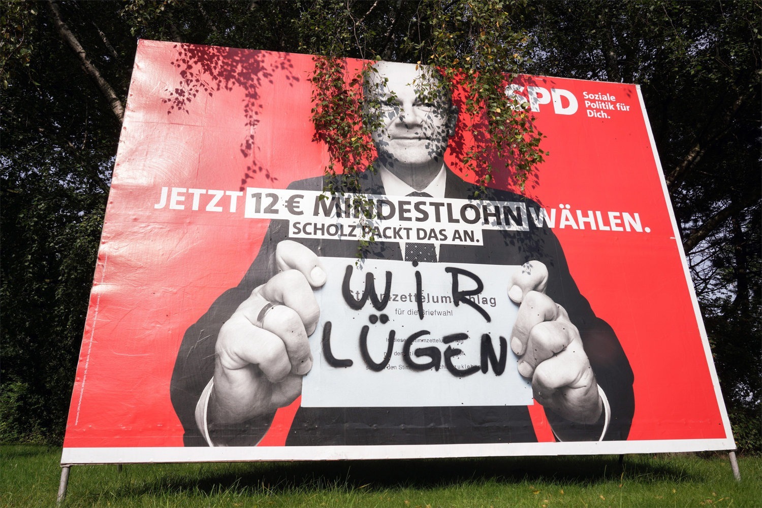 Foto: Übermaltes SPD-Wahlplakat mit Olaf Scholz, der ein Schild „Wir lügen“ hält