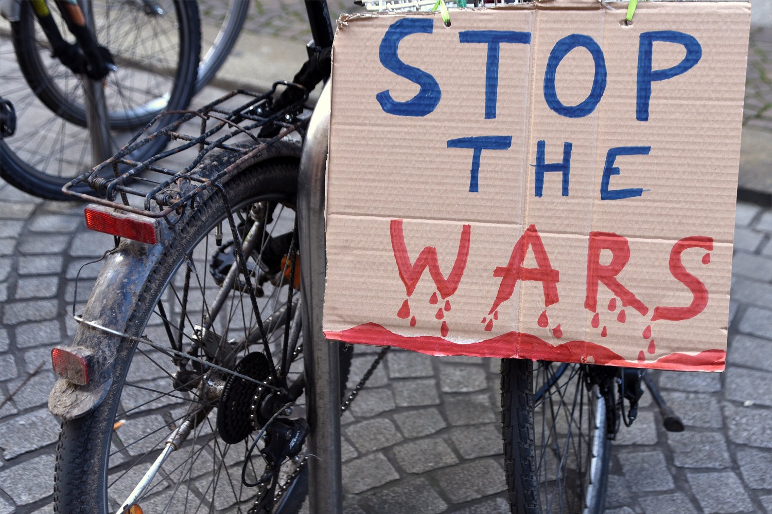 Foto: Pappschild „Stop the Wars“ an einem abgestellten Fahrrad