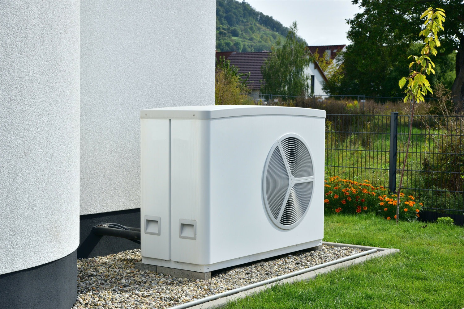 Foto: Wärmepumpe neben einem Einfamilienhaus im Garten
