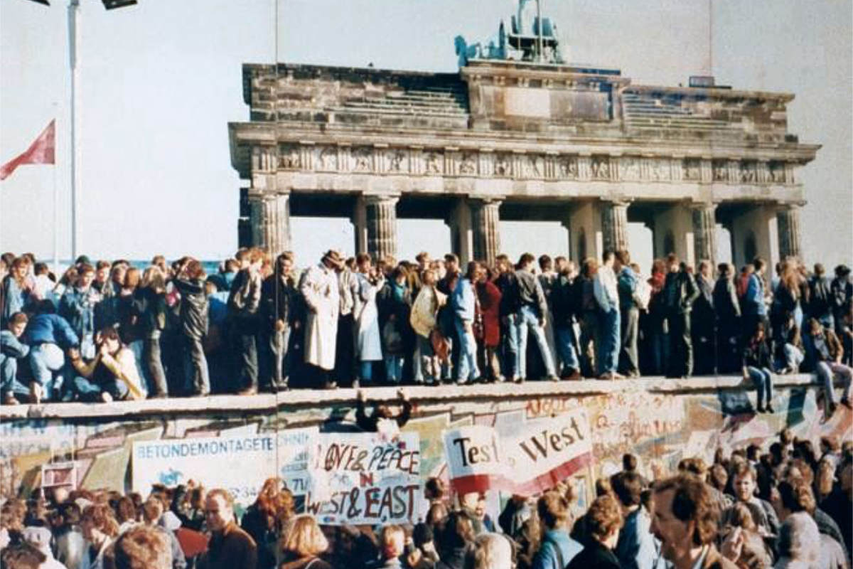Menschenmenge auf der Berliner Mauer vor dem Brandenburger Tor im November 1989