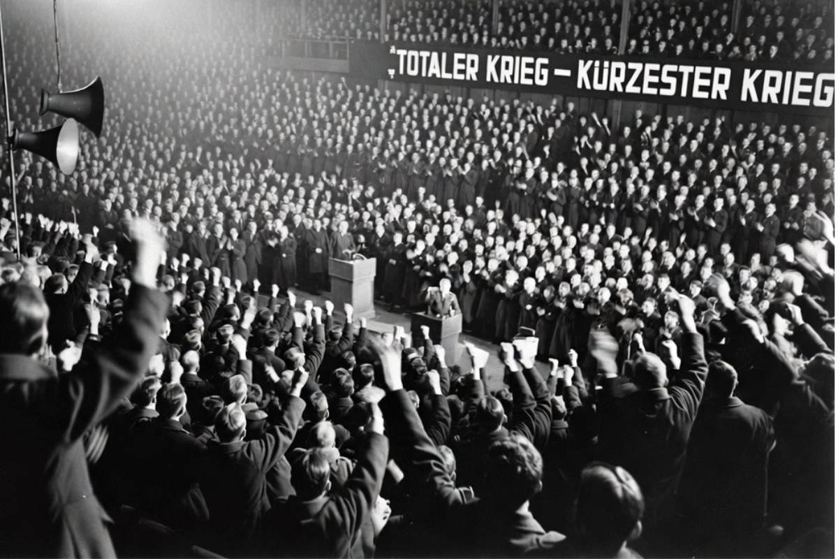 KI-generierte Bildrekonstruktion nach historischer Vorlage: Jubelnde Menge im Berliner Sportpalast am 18. Februar 1943 unter dem Banner „Totaler Krieg – kürzester Krieg“