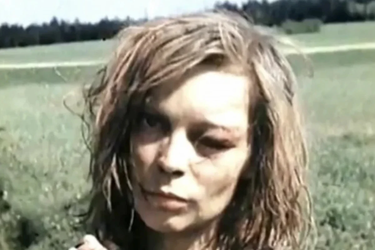 Filmstandbild vom 8. Mai 1945 bei Rokycany: junge Frau mit zerzaustem Haar und verletztem Auge auf einer Wiese (Aufnahme: Captain Oren W. Haglund, US Army Air Forces)