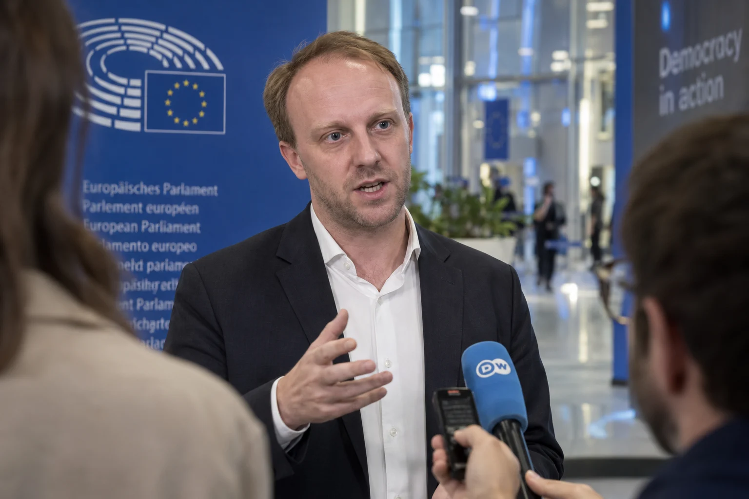 KI-generierte Illustration: Daniel Freund gibt vor dem Europäischen Parlament ein Interview